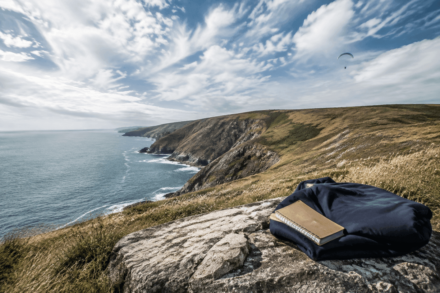Paraglider soaring above a coastline