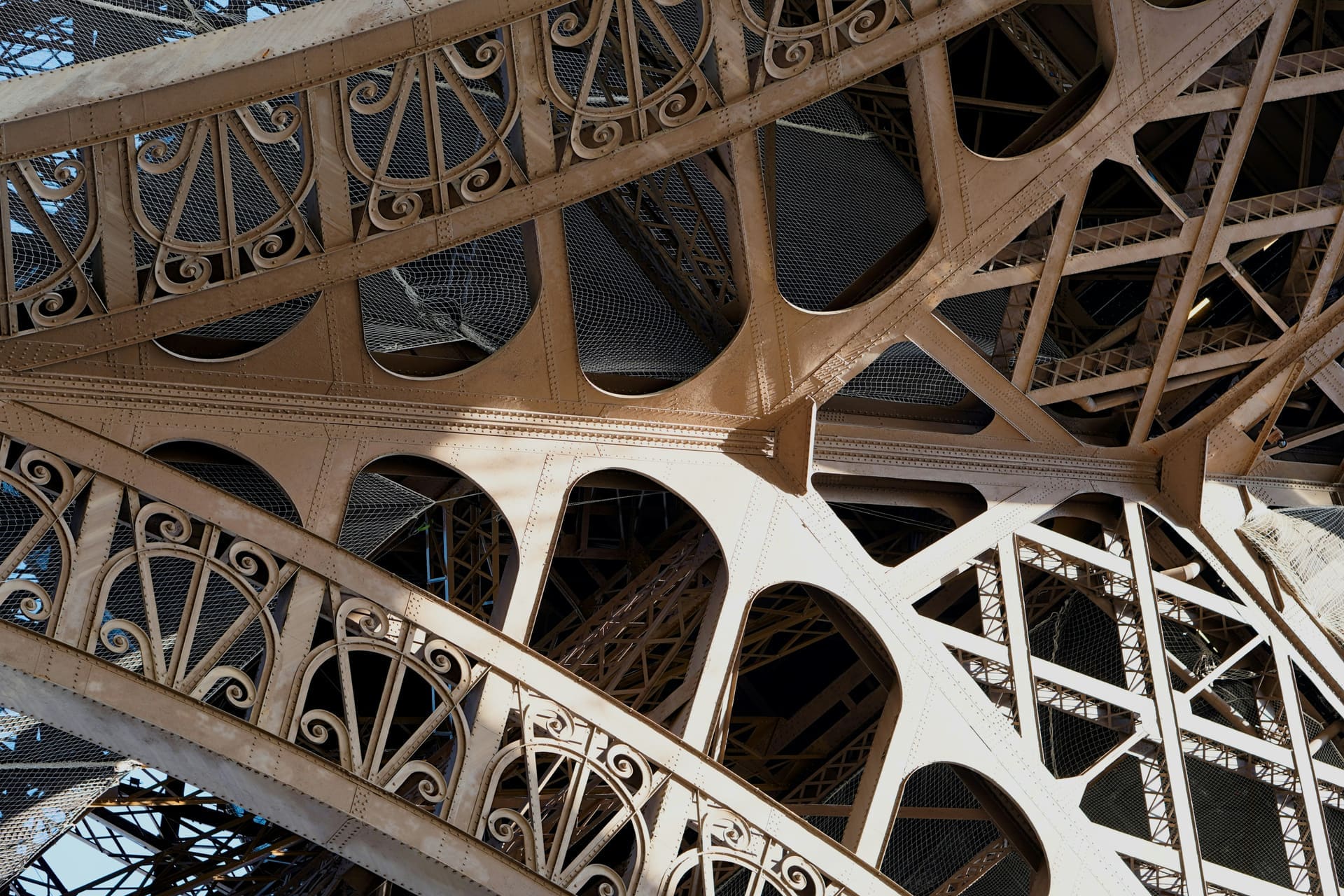 Looking up at the Eiffel Tower's iron lattice structure