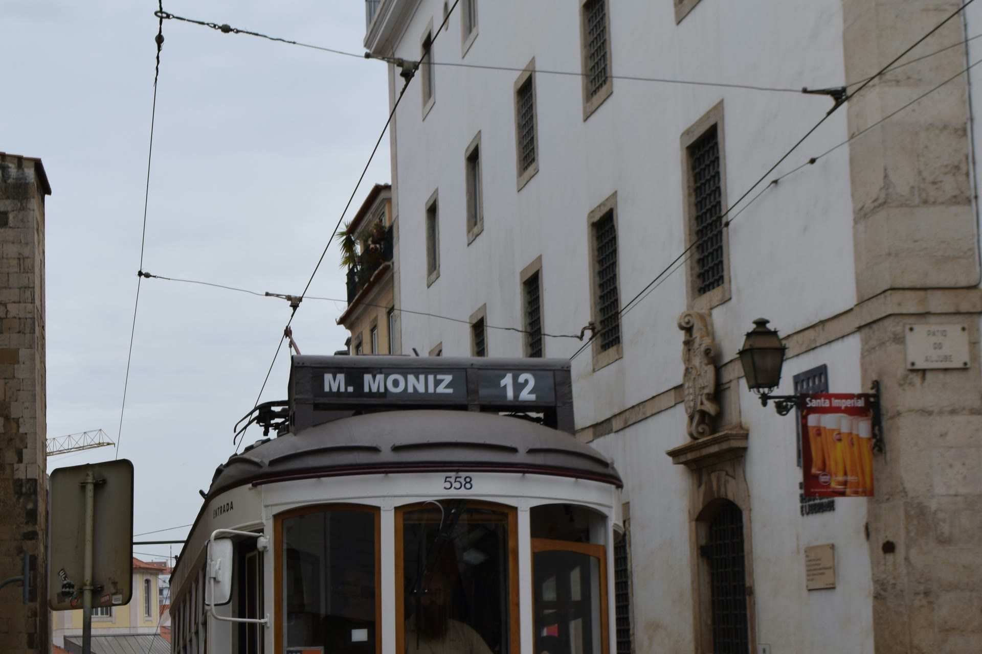 Yellow tram climbing a narrow street in Lisbon's Alfama district